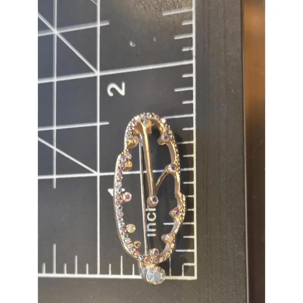 Golden with rhinestones melted clock brooch